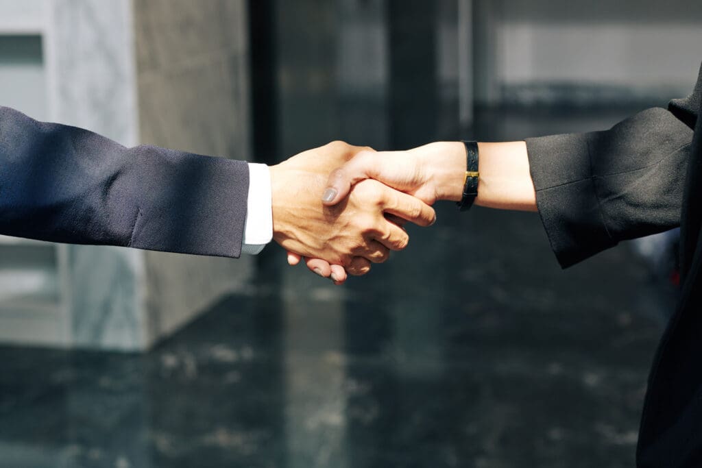 Close-up image of man and woman shaking hands after meeting