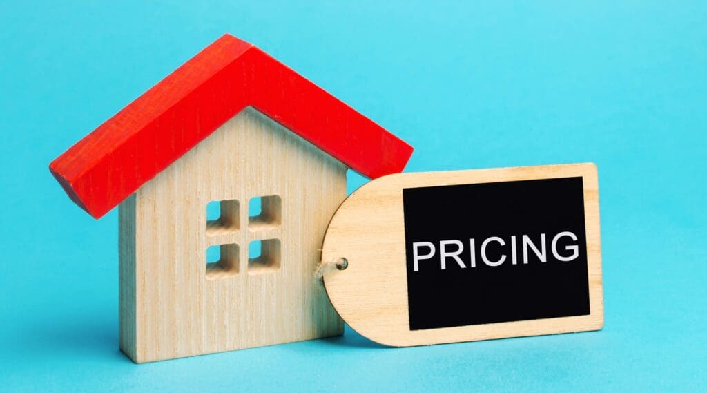 Wooden house with the word Pricing. Concept of pricing real estate.