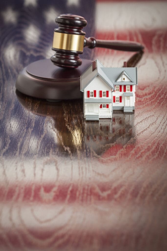 How to help a client purchase a foreclosure.  Small House and Gavel on Wooden Table 