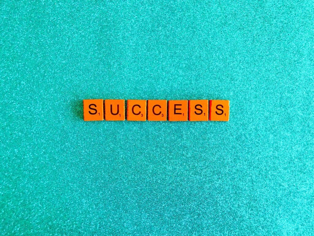 Success spelled out in wooden tiles on a blue background