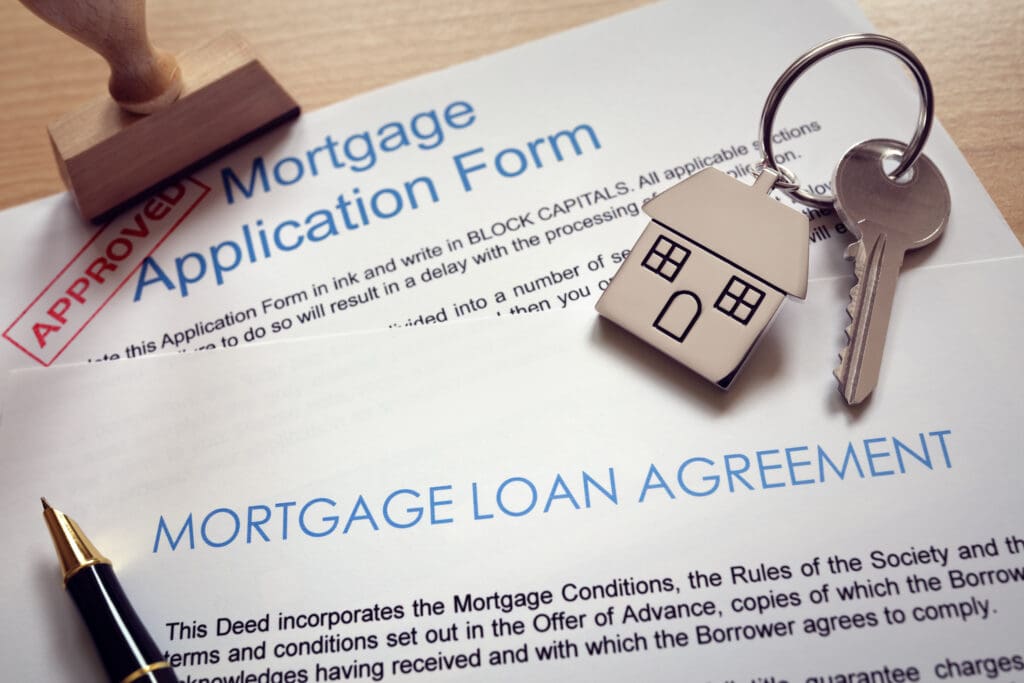 Mortgage loan agreement application with key on house shaped key ring