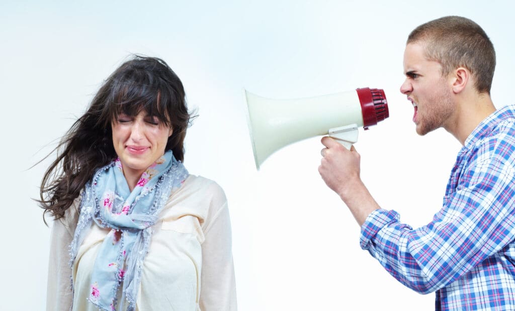 Profile of a young man shouting at a young woman through a bullhorn