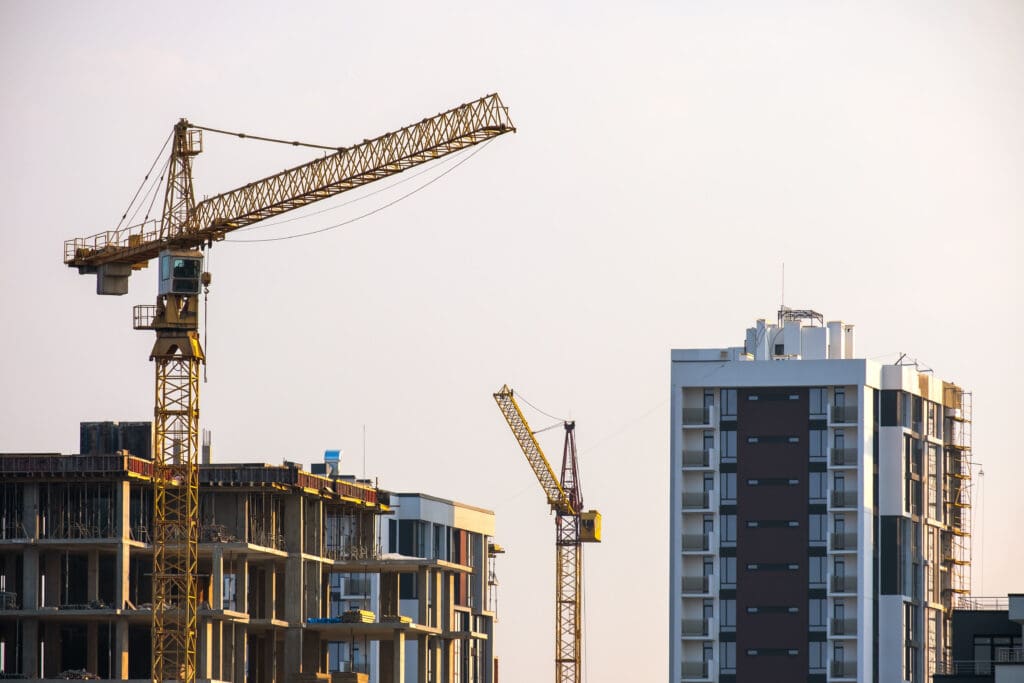 Tower cranes and high residential buildings under construction. Real estate development.